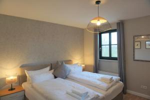 een slaapkamer met 2 bedden en een kroonluchter bij Landhaus Storchennest - komfortable Appartements für 2-5 Personen in Reestow