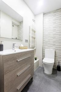 a bathroom with a sink and a toilet in it at Precioso piso moderno: Terraza, A/C, NetFlix, WiFi in Valencia