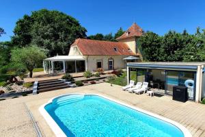 una casa con piscina di fronte a una casa di Villa du Bonheur - 10 pers. - Spa - Sauna - Hammam 