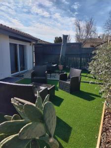 a garden with chairs and a table and a cactus at Gite de PHAM in Belberaud