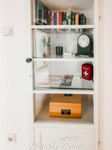 a book shelf with a clock and books at Friendly Home - Gemütliches Backsteinhaus in Bornheim