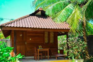 a small wooden cabin with a table and chairs at High Park Hotel in Nilaveli