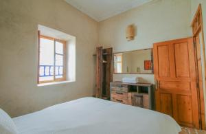 エッサウィラにあるStella 1 - joli appartement en médina avec cheminéeのベッドルーム(ベッド1台、シンク、鏡付)