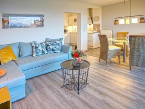 a living room with a blue couch and a table at Meer mit Blick, Dat witte Hus in Rettin