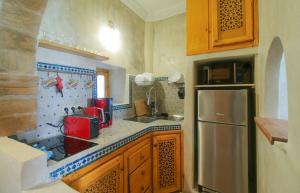 cocina con fregadero y nevera en Stella 1 - joli appartement en médina avec cheminée, en Essaouira