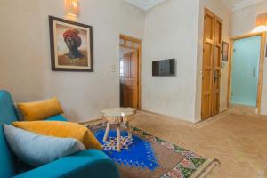 索維拉的住宿－Stella 1 - joli appartement en médina avec cheminée，客厅配有蓝色的沙发和桌子