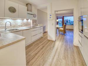 a kitchen with white cabinets and a dining room at Meer mit Blick, Dat witte Hus in Rettin +8 photos