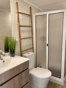a bathroom with a toilet and a sink and a shower at Alojamento confortável a 2 min da Praia in Horta