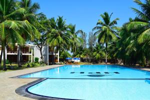 una gran piscina con palmeras en el fondo en High Park Hotel, en Nilaveli