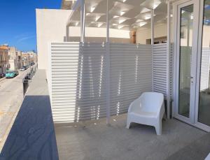 a white chair sitting on the side of a building at Catalina in San Vito lo Capo