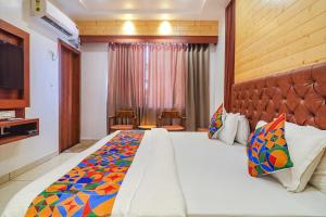 Habitación de hotel con cama grande y TV en FabHotel Grand Arya en Patna