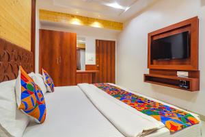 a bedroom with a bed with a flat screen tv at FabHotel Grand Arya in Patna
