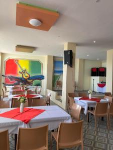 restauracja ze stołami i krzesłami oraz obrazem na ścianie w obiekcie Hotel Dorotea w mieście Puerto Galera