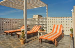 three orange chairs sitting on a rooftop patio at Stella 2 - appartement spacieux avec cheminée medina Essaouira in Essaouira