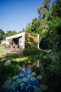 ein Haus mit einem Teich davor in der Unterkunft Quinta do Pomar Maior in Arouca