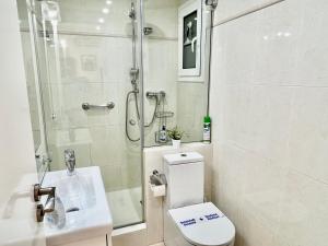 a bathroom with a shower and a toilet and a sink at Sitges Seafront Ribera Apartment in Sitges +52 photos