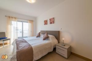 Habitación blanca con cama y ventana en Sol & Cidade 73 by Destination Algarve en Lagos