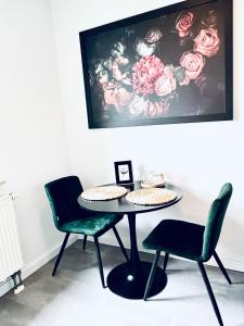 uma mesa e cadeiras num quarto com uma pintura em Gemütliches Studio - Elias- mit Küche, WLAN, Smart-TV & Panoramablick in Citynähe em Erfurt