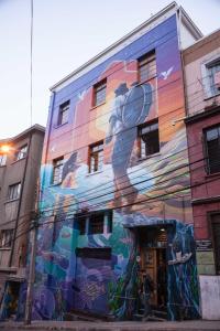 a building with a mural of a woman holding a tennis racket at Hostal Po in Valparaíso