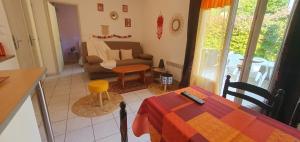 a living room with a table and a couch at Petite maison au calme garrigue et mer Montpellier in Teyran