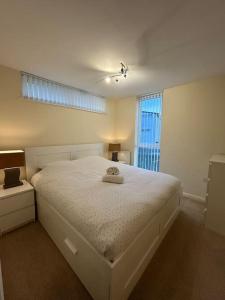 Comfortable 3-Storey House with Free Car Parking في مانشستر: غرفة نوم بسرير ابيض ونافذة