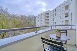 a balcony with a table and chairs and a building at LOGEMENT AARON in Evry-Courcouronnes