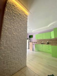 una cucina con armadi verdi e un muro di mattoni di Апартаменты в ЖК Комфорт Таун a Kiev