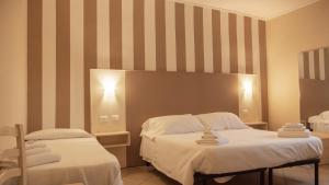 a hotel room with two beds with towels on them at Hotel La Smorfia in Castiglioncello