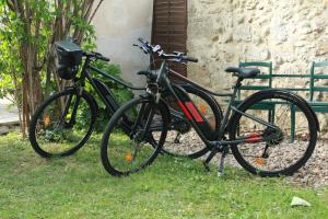 two bikes parked in the grass next to a building at Relais de la Renaissance in Saint-Michel-de-Montaigne