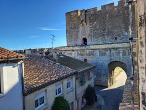 an old castle with an archway and some buildings at Le Repaire du Soleil in Aigues-Mortes