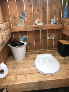 a wooden bathroom with a toilet and a bucket at La lodge vue mer in Nice
