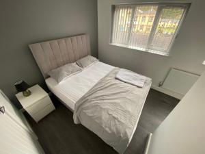 a small bedroom with a bed and a window at Entire Modern House in Greetland
