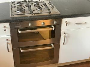 a stainless steel oven with a stove top in a kitchen at Private Rooms In A Cheerful 4-Bedroom Town House in Broughton +18 photos