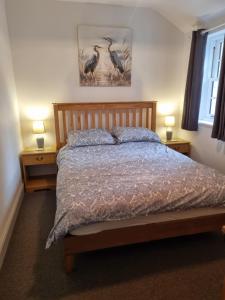 a bedroom with a bed with two nightstands and two lamps at John's Cottage in Wedmore