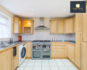 a kitchen with wooden cabinets and a stove top oven at 4 Bed Monthly Discount Family Contractors Business By Fobis Suites Short Lets & Serviced Accommodation Hatfield in Hatfield
