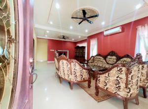 a living room with red walls and a table and chairs at Villa Mikayla Homestay - Alor Setar in Alor Setar