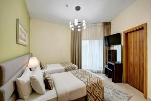 Cette chambre comprend deux lits et une télévision. dans l'établissement Radiance Premium Suites, à Dubaï