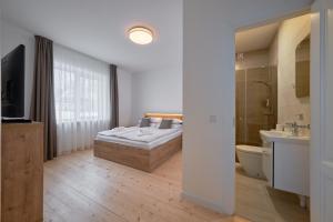 een slaapkamer met een bed en een badkamer met een televisie bij Jonavos alpakų svečių namai in Jonava