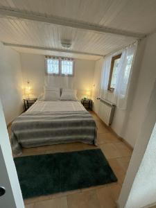 a bedroom with a large bed and two windows at Villa Acacia in Vallauris +3 photos