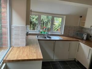 a kitchen with a sink and a window at Rooms In A Victorian Comfortable 4-bedroom house in Milton Keynes Rooms Not En-suites in Wolverton