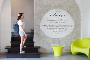 a woman standing on the stairs in a room at Hotel La Smorfia in Castiglioncello