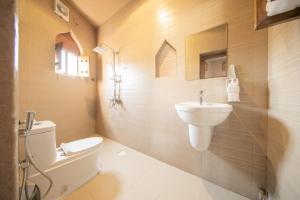 a bathroom with a white toilet and a sink at Alaqur View Inn نزل واجهة العقر in Nizwa