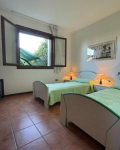 een slaapkamer met 2 bedden en een raam bij Fantastic villa with pool surrounded by nature in Palazzo Vianello