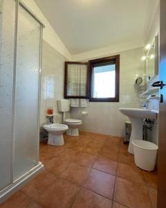 een badkamer met 2 toiletten, een wastafel en een douche bij Fantastic villa with pool surrounded by nature in Palazzo Vianello