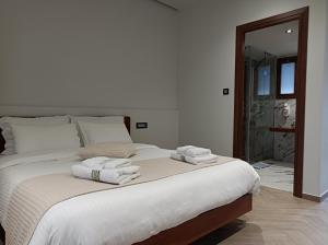 The Flower Of Monemvasia Hotel في مونيمفاسيا: غرفة نوم بسرير كبير عليها مناشف