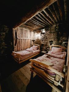um quarto com duas camas num chalé de madeira em Ethnic Hostel Shatili em Shatili
