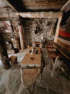 um quarto com uma mesa de madeira e cadeiras num camarote em Ethnic Hostel Shatili em Shatili
