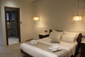 a bedroom with a bed with two towels on it at The Flower Of Monemvasia Hotel in Monemvasia