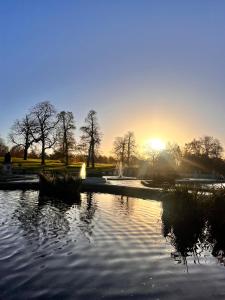 un parc avec un étang et un coucher de soleil en arrière-plan dans l'établissement Hyde Park,3 min walk,Family home! 2 Bedrooms & 2 Bathrooms Apartment! Fantastic Location, à Londres