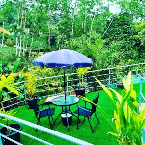 a table and chairs with an umbrella on a balcony at Paradise Breeze Apartment in Mahe